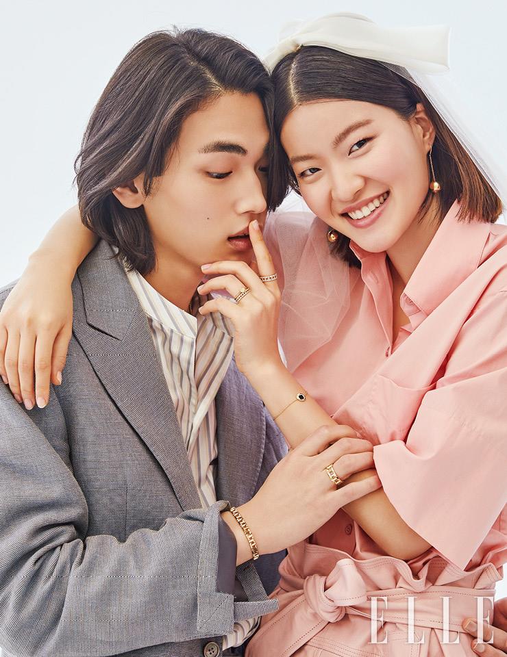 현근의 알파벳 T가 체인 형태로 교차된 티파니 티 트루 내로 브레이슬렛과 티파니 티 트루 와이드 링은 가격 미정, 모두 Tiffany & Co. 스트라이프 패턴의 셔츠는 59만원, Salvatore Ferragamo. 포멀 재킷은 1백89만원, Jaybaek Couture. 유진이 착용한 블랙 오닉스로 선명함을 더한 티파니 티 컬러 티 투 서클 브레이슬렛과 18K 옐로골드 링에 팬시 옐로 모디파이드 브릴리언트 다이아몬드를 세팅한 티파니 트루 링, 교차된 T 위에 다이아몬드를 세팅한 티파니 티 트루 파베 내로 링과 와이드 링, 볼드한 볼 장식의 티파니 하드웨어 볼 후크 이어링은 가격 미정, 모두 Tiffany & Co. 셔츠는 69만원, 쇼츠는 1백35만원, 모두 Salvatore Ferragamo. 리본 장식의 헤어피스는 가격 미정, Angtt.