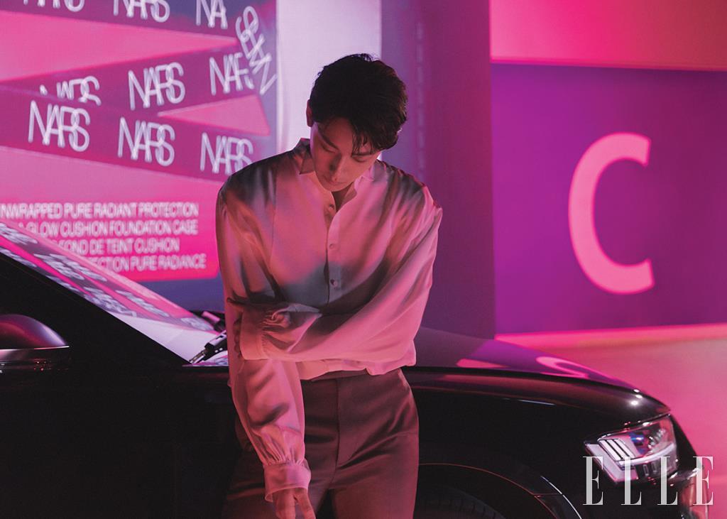 화이트 퍼프 블라우스와 화이트 타이, 그레이 브라운 팬츠는 모두 Kimseoryong Homme. 