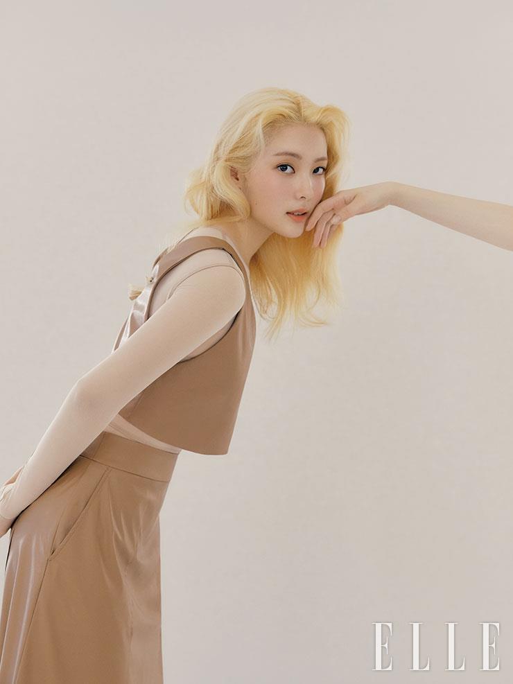 스킨 컬러의 시스루 보디수트는 Ann Demeulemeester. 브라운 컬러의 비건 레더 슬리브리스 톱과 스커트는 모두 Vimun.