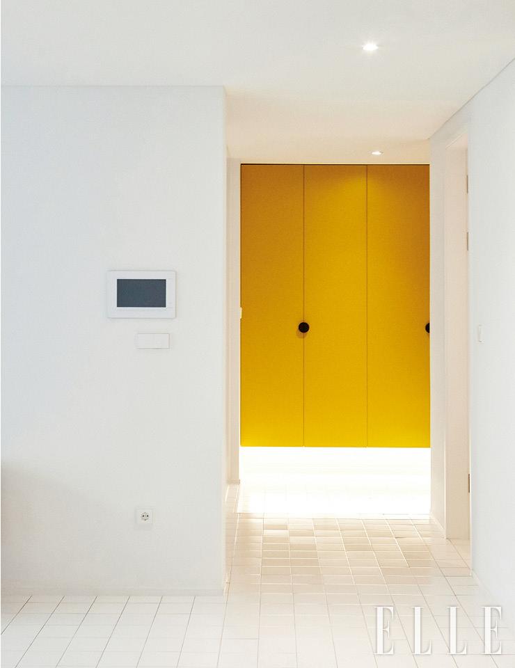 통일감과 개방감을 주기 위해 집 안 전체에 같은 타일 바닥을 깔았다. 노란 신발장은 제작한 것. 