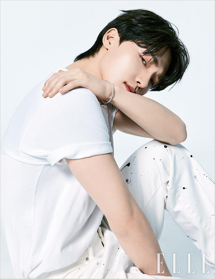 화이트 티셔츠는 Ballon. 블랙 프린트 디테일이 있는 화이트 데님 팬츠는 Tonywack. 팔찌는 Hei.
