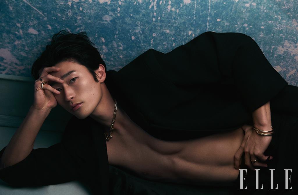 오른손 새끼손가락에 낀 티파니 T1 와이드 풀 다이아몬드 링, 약지에 낀 옐로골드 티파니 T 투 링, 볼드한 체인의 티파니 하드웨어 그레듀에이티드 링크 네크리스, 왼손의 티파니 락 다이아몬드 악센트 뱅글, 레이어드한 티파니 락 뱅글, 약지에 낀 티파니 T 트루 와이드 링은 모두 Tiffany & Co. 맥시 코트는 Gucci.