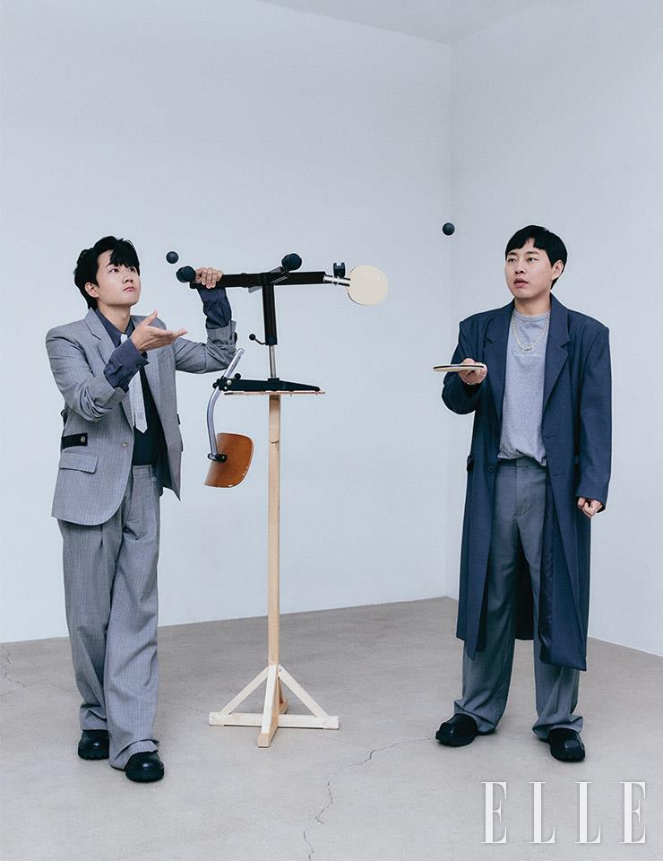 이용진이 입은 그레이 자켓과 팬츠는 Off-white&trade;. 셔츠와 패턴 타이는 스타일리스트 소장품, 슈즈는 Yowe. 이진호가 입은 그레이 컬러 티셔츠는 Acne Studios. 와이드 팬츠와 오버사이즈 코트는 스타일리스트 소장품, 스퀘어토 더비 슈즈는 Yowe.