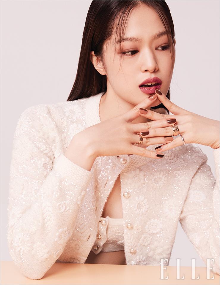 따스한 웜 톤 피부의 성민에게는 울트라 르 뗑, BD21을 발라 피부 톤을 더욱 고르게 연출한다. 레 꺄트르 옹브르, 328 블러리 모브를 눈가에 퍼뜨려 발라 우묵한 깊이감을 부여하고, 입술엔 고혹적인 레드 베이지빛의 루쥬 알뤼르, 211 쉽띨을 바른다. 성민의 손톱에 절반씩 매치해 재미를 더한 골드 언더톤의 네일은 르 베르니, 951 오리지널, 953 에쌍씨엘, 955 인스피레이션, 957 임펄션, 959 인피니트. 사용 제품은 모두 Chanel.양손에 착용한 코코 크러쉬 링과 스팽글 장식의 브라톱, 카디건은 모두 Chanel.