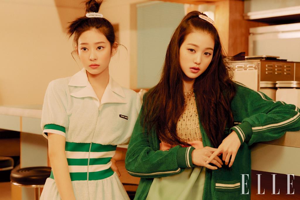 민주가 입은 밴드 디테일의 아쿠아 원피스와 헤어핀, 원영이 입은 주얼 장식 원피스와 그린 카디건, 헤어핀은 모두 Miu Miu.