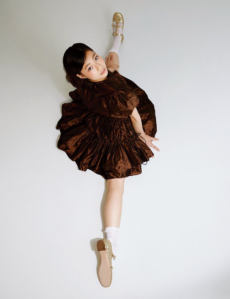 퍼프 소매의 티어드 원피스와 골드 글리터 신발은 모두 Miu Miu.