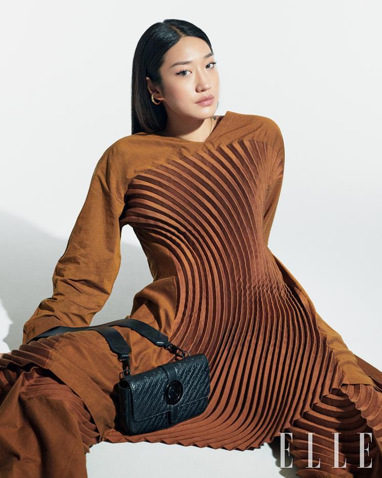  몽블랑 과거 레터링에서 영감받은 M패턴이 적용된 스타일리시한 디자인의 ‘울트라블랙 크로스 클러치’는 Montblanc. 톱과 팬츠는 모두 Issey Miyake.