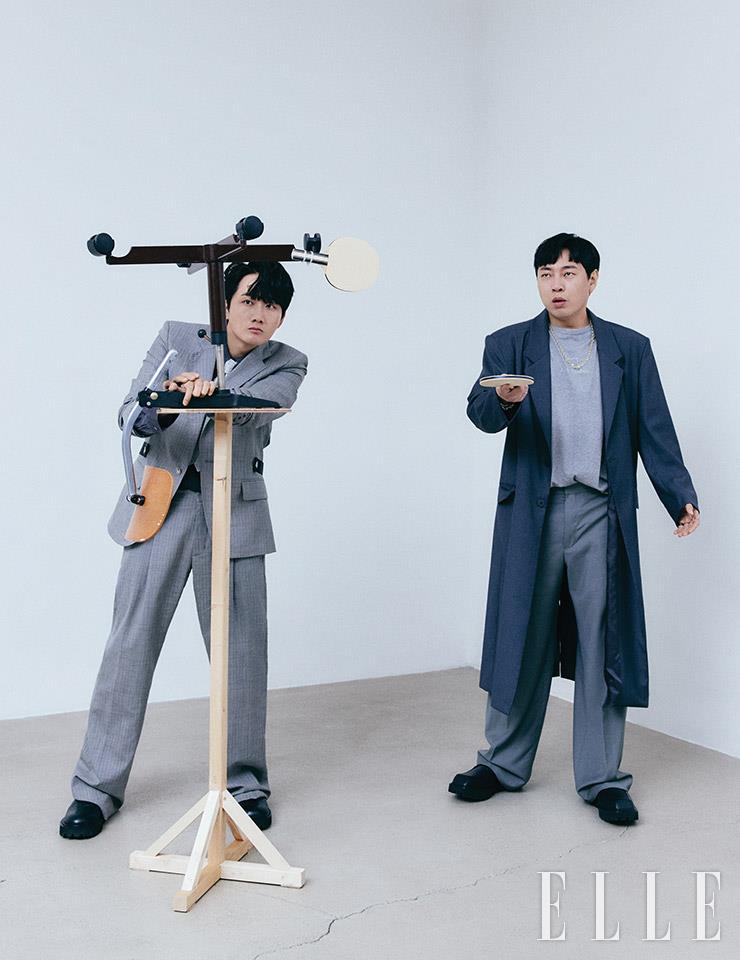 이용진이 입은 그레이 자켓과 팬츠는 Off-white&trade;. 셔츠와 패턴 타이는 스타일리스트 소장품, 슈즈는 Yowe. 이진호가 입은 그레이 컬러 티셔츠는 Acne Studios. 와이드 팬츠와 오버사이즈 코트는 스타일리스트 소장품, 스퀘어토 더비 슈즈는 Yowe.