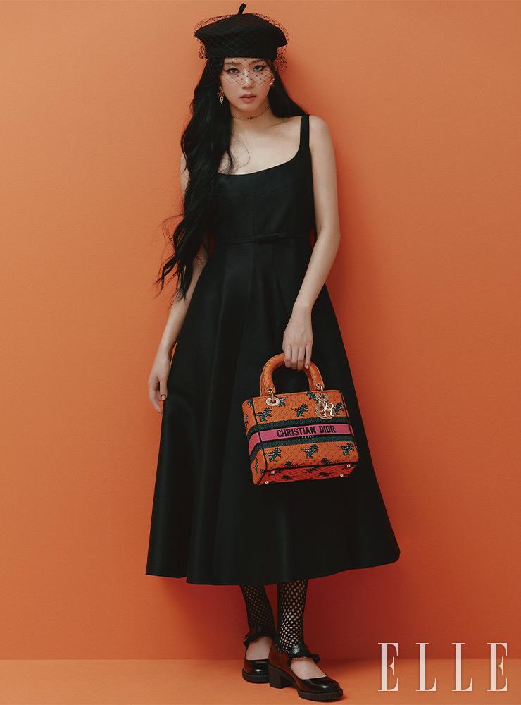 미디 길이의 블랙 드레스와 베레, 이어링, CD 로고 장식의 초커, 피시넷 스타킹, 블랙 메리 제인 슈즈, 레이디 디 라이트 백은 모두 Dior.