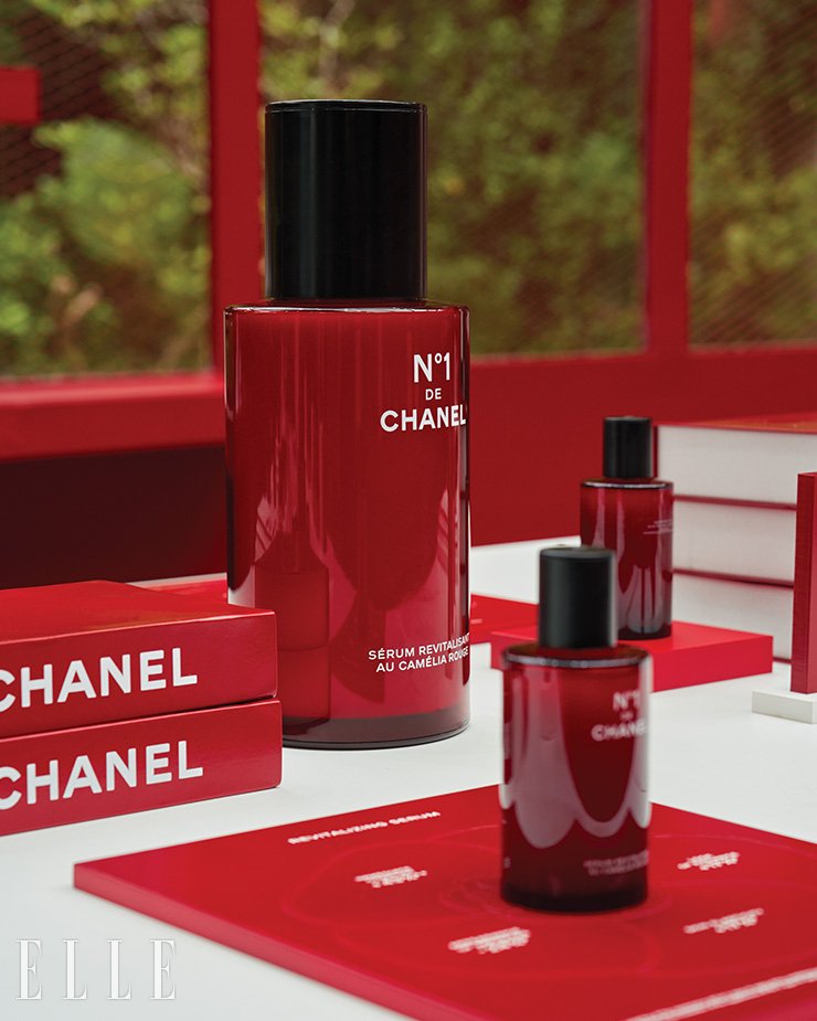 행사장에 놓여 있는 N°1 DE CHANEL 레드 까멜리아 세럼 100ml와 이를 기념하는 오브제.