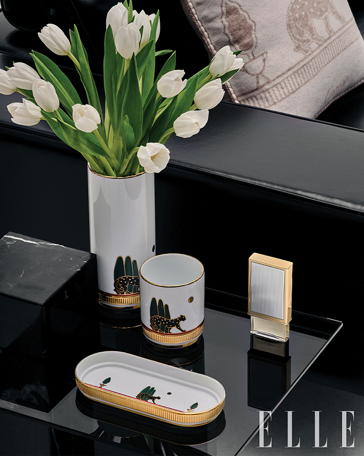 메리노 울 & 캐시미어 소재의 팬더 드 까르띠에 쿠션, 리모주 도자기 팬더 드 까르띠에 화병, 펜슬 홀더, 트링킷 트레이, 스트라이프 장식의 케이스와 리필 가능한 30ml 향수로 구성된 레 네쎄세르 아 퍼퓸 까르띠에는 모두 Cartier.