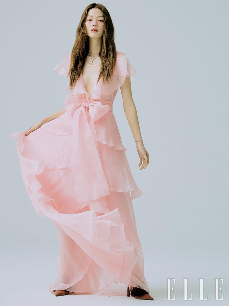 시폰 소재의 핑크 티어드 드레스는 Blumarine. 뱀 모티프의 네크리스와 플라워 모티프의 브레이슬렛은 모두 Bvlgari. 링은 Cartier. 깃털 장식의 슈즈는 Jimmy Choo.