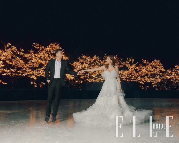 풍성한 러플 장식의 볼륨 드레스는 Zuhair Murad by Maison Reve. 블랙 슈트는 Kinloch Anderson, 셔츠는 Lord and Tailor.