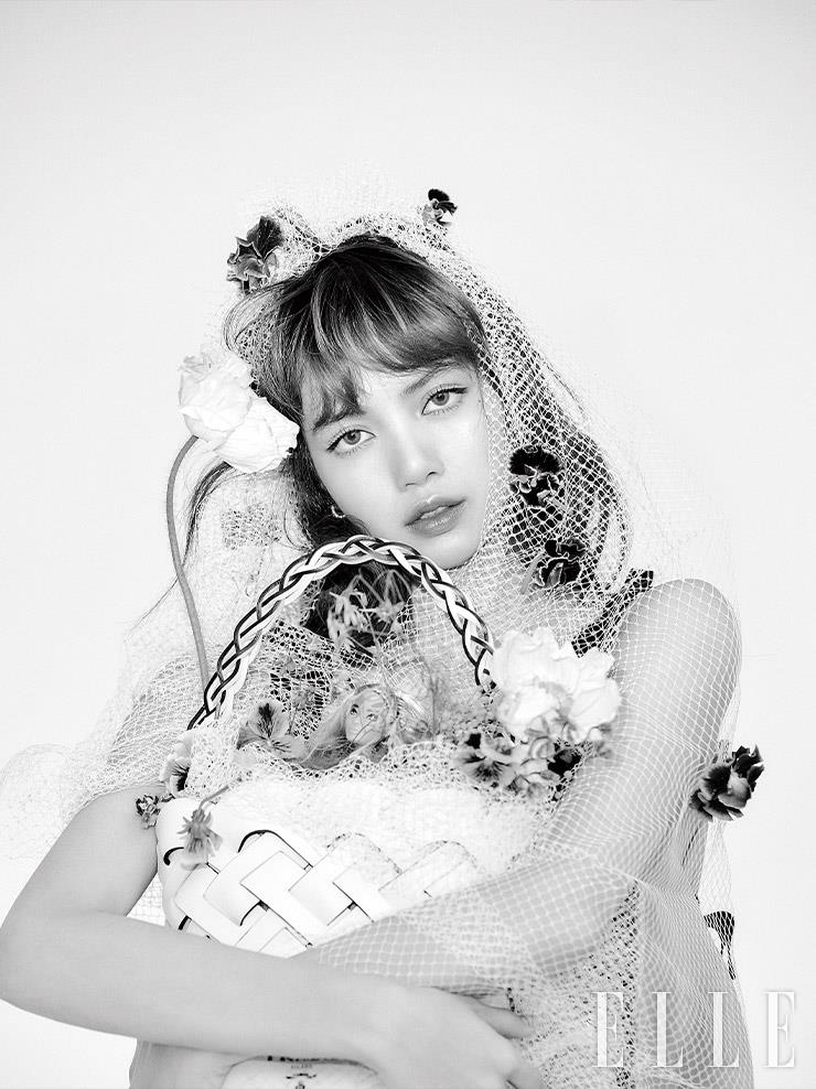 위빙 장식의 비텔로 인트레치오 백, 레더 슬리브리스 톱은 모두 Prada.