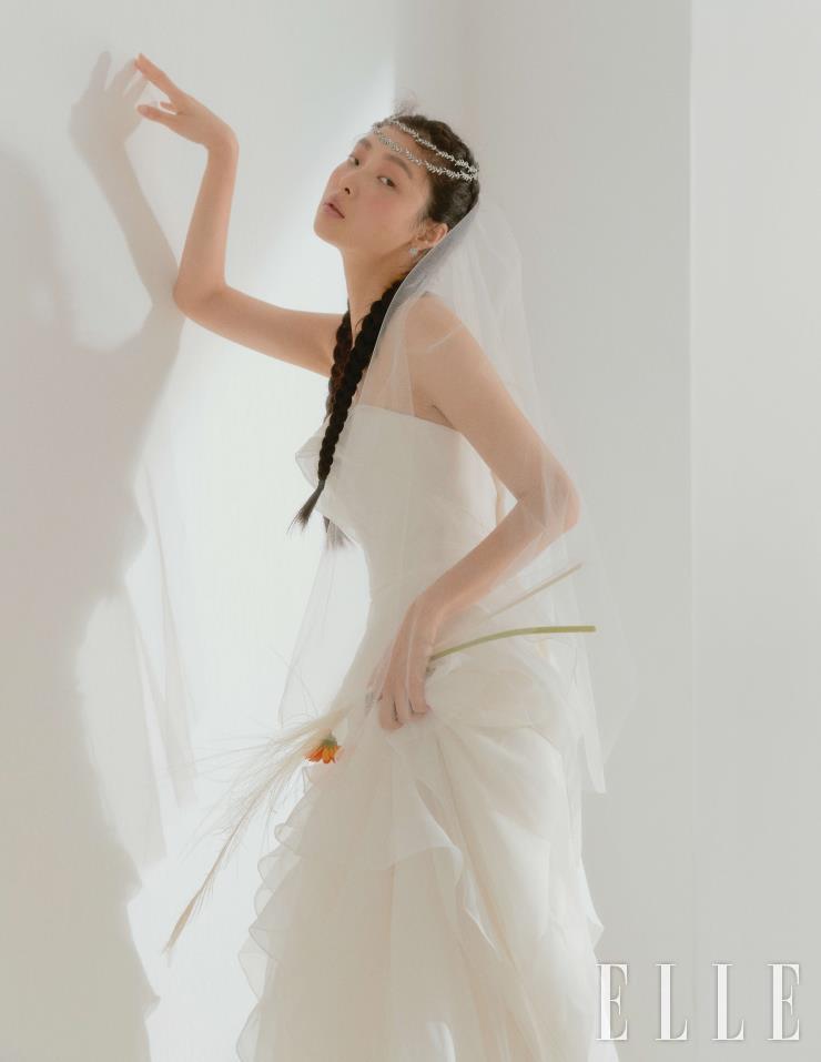 전체적인 러플 디테일의 튜브 톱 드레스와 베일, 헤어 오브제는 모두 Leemyungsoon Wedding. 이어링과 링은 Golden Dew. 