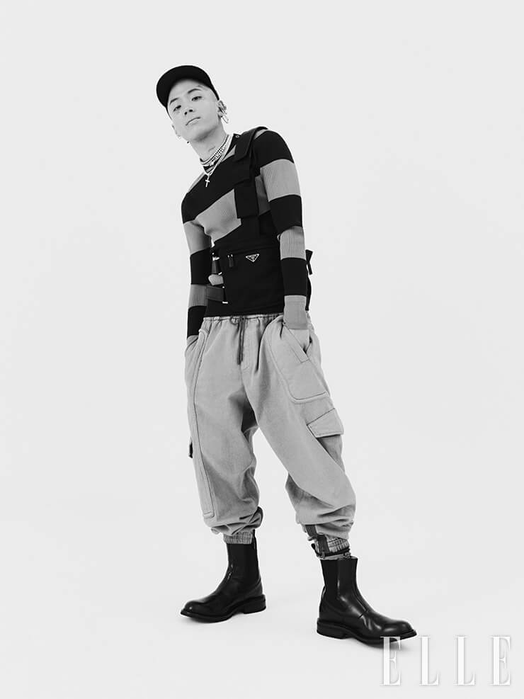 루피가 입은 블루 스트라이프 니트와 나일론 하네스 스트랩 백은 가격 미정, 모두 Prada. 데님 카고 조거 팬츠는 가격 미정, Ermenegildo Zegna XXX. 크리스털 장식의 멀티 후프 이어 커프는 가격 미정, Alexander McQueen. 블랙 첼시 부츠는 1백36만5천원, Bottega Veneta.