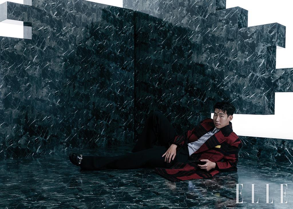 타탄체크 패턴의 코트와 스트라이프 셔츠, 블랙 팬츠, 로퍼는 모두 Louis Vuitton Men’s Collection.