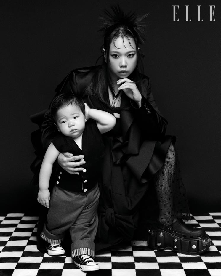 현희가 입은 리본 포인트의 블랙 재킷과 스커트는 모두 Comme des Garcons. 레이스 스커트는 Dew E Dew E. 플랫폼 슬라이드는 Balenciaga. 준범이 입은 니트 베스트와 팬츠는 모두 Thom Browne. 스니커즈는 Converse.