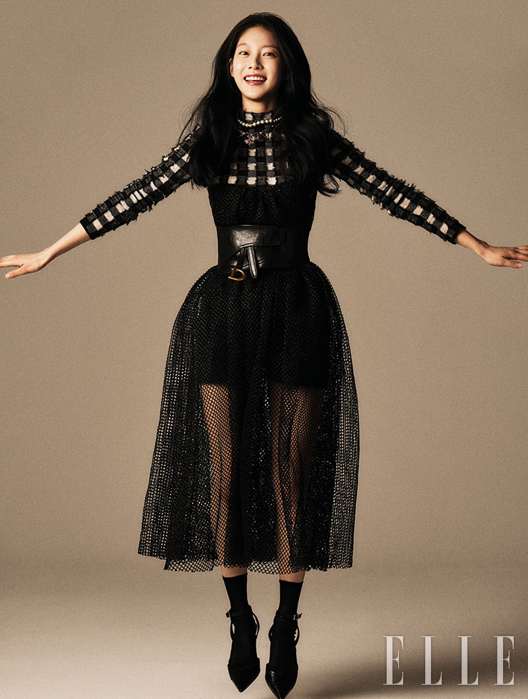 체크 스웨터와 점프수트, 블랙 샤 스커트, 벨트, 삭스, 슈즈, 와이드 진주 장식 네크리스는 모두 Christian Dior. 