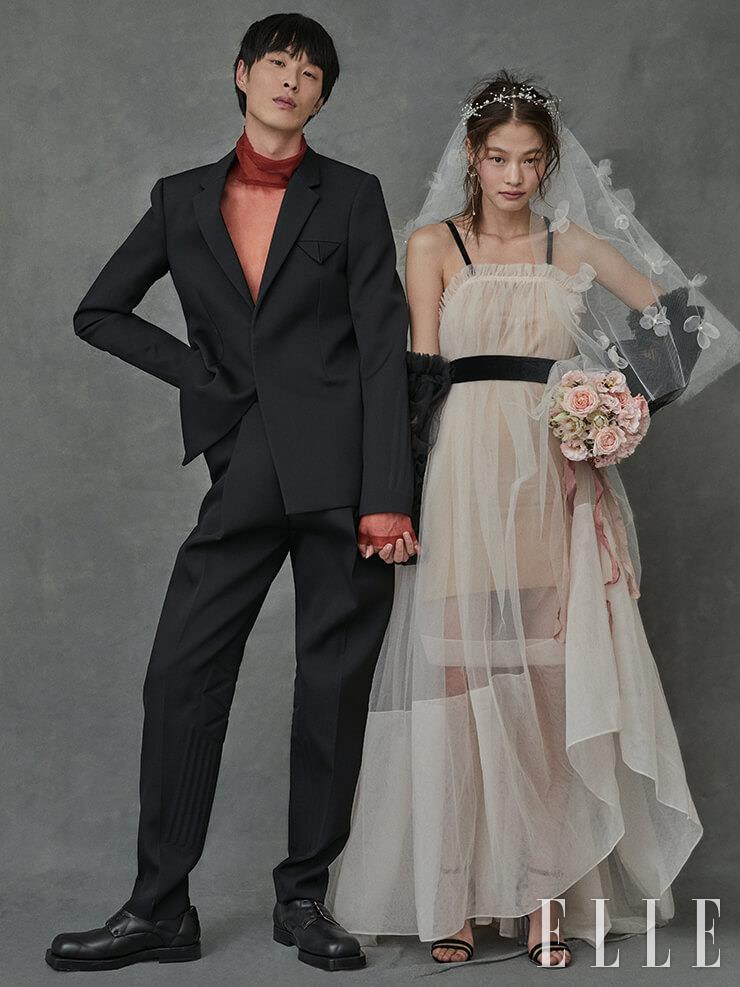 박진이 입은 메시 터틀넥과 블랙 재킷, 팬츠, 슈즈는 가격 미정, 모두 Bottega Veneta. 김아현이 입은 핑크 컬러 드레스는 가격 미정, Minjukim. 골드 이어링은 가격 미정, Swarovski. 티아라와 플라워 장식의 베일은 가격 미정, 모두 Angtt. 스트랩 힐은 가격 미정, Louis Vuitton. 벨트는 스타일리스트 소장품.