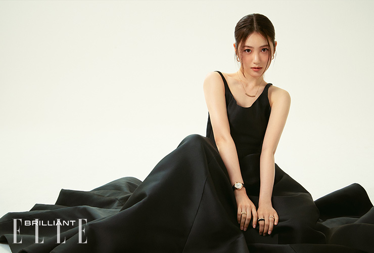 ‘클래쉬 드 까르띠에’ 이어링, ‘클래쉬 드 까르띠에’ 네크리스, 오른팔에 착용한 블루 앨리게이터 레더 스트랩 ‘발롱 블루 드 까르띠에’ 워치, 약지에 착용한 더블로우 ‘클래쉬 드 까르띠에’ 링, 왼손 검지에 착용한 블랙 오닉스 ‘클래쉬 드 까르띠에’ 라지 링, 약지에 착용한 ‘클래쉬 드 까르띠에’ 링은 모두 가격 미정 CARTIER. 블랙 U넥 쿠튀르 롱 드레스는 가격 미정 VALENTINO.