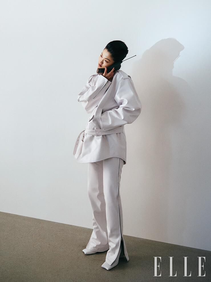 오버사이즈 바이커 재킷과 지퍼 여밈 장식의 화이트 팬츠, 스퀘어 토 앵클부츠는 모두 Balenciaga.