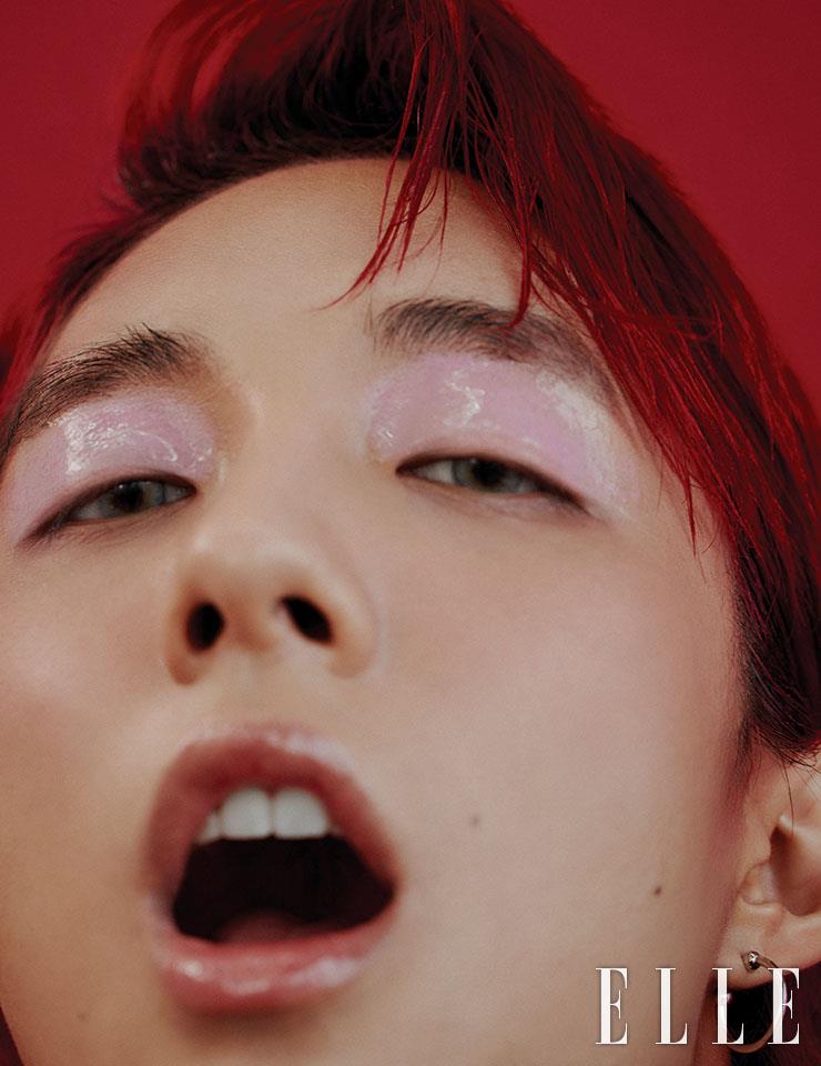 연보랏빛 크림 섀도를 눈꺼풀에 바른 다음 그 위에 립글로스를 덧발라 광택감을 극대화한다. 베이지 컬러의 블러셔를 앞쪽 볼부터 광대뼈까지 널찍이 바르고 투명 립글로스를 입술에 도톰히 발라준다. 후프 이어링은 Rocking Ag. 