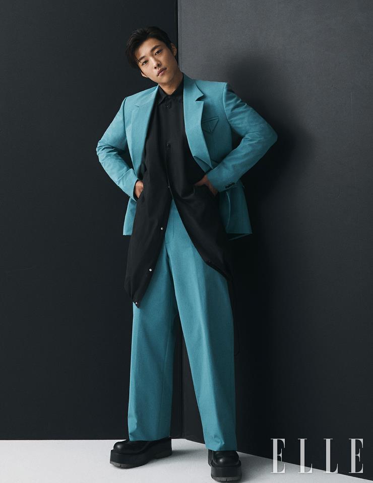 밑단 스트링 디테일의 블랙 셔츠와 블루 수트, 슈즈는 모두 Bottega Veneta.