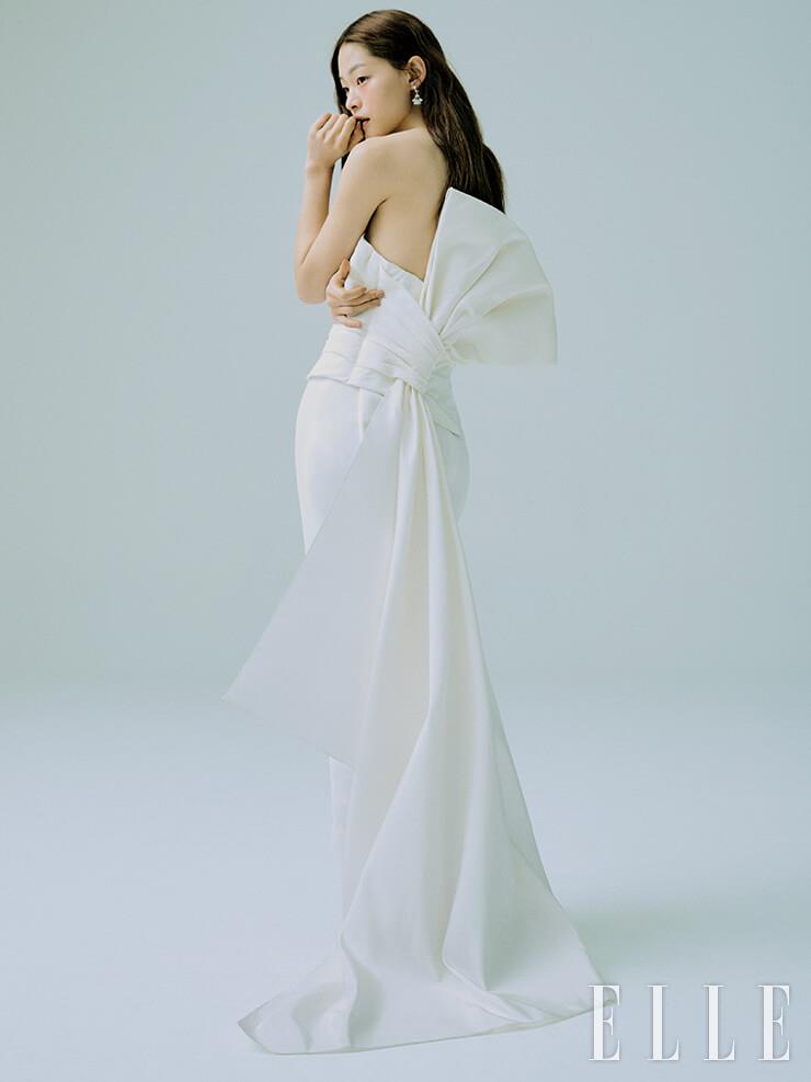 리본 디테일이 드레시한 톱과 포멀 팬츠는 Oscar de La Renta by Soyoo Bridal. 샹들리에 같은 이어링은 Bvlgari.