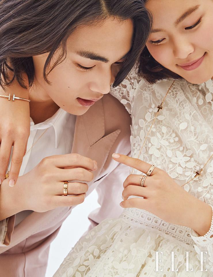 현근이 착용한 T 모양이 양각으로 새겨진 티파니 티 투 내로 링과 모던키 네크리스는 가격 미정, 모두 Tiffany & Co. 톤다운된 핑크 컬러의 재킷과 화이트 셔츠는 가격 미정, 모두 Dior Men. 유진이 검지에 낀 티파니 티 투 내로 링, 중지에 낀 티파니 티 와이어 FC링, 함께 레이어드한 티파니 티 트루 파베 내로 링, T 펜던트 위에 마더 오브 펄을 세팅한 티파니 티 투 네크리스, 티파니 티 와이어 브레이슬렛은 가격 미정, 모두 Tiffany & Co. 플라워 아플리케 장식의 드레스는 가격 미정, Costarellos by Beyond the Dress. 