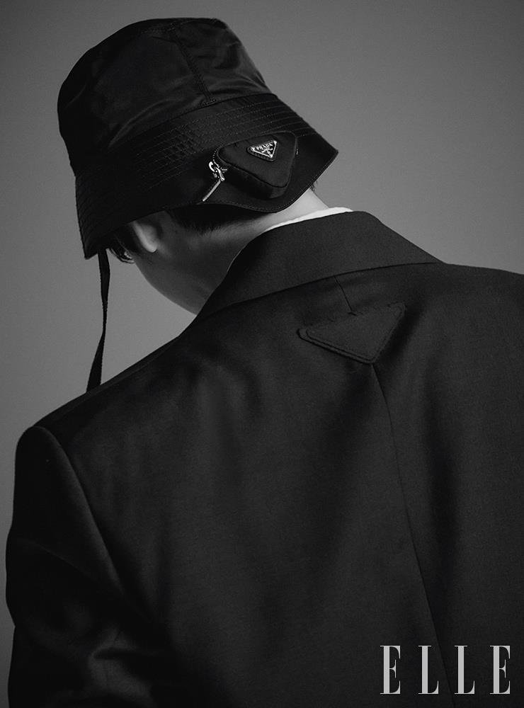 로고 디테일의 재킷과 셔츠, 삼각 포켓 장식의 버킷 햇은 모두 Prada.
