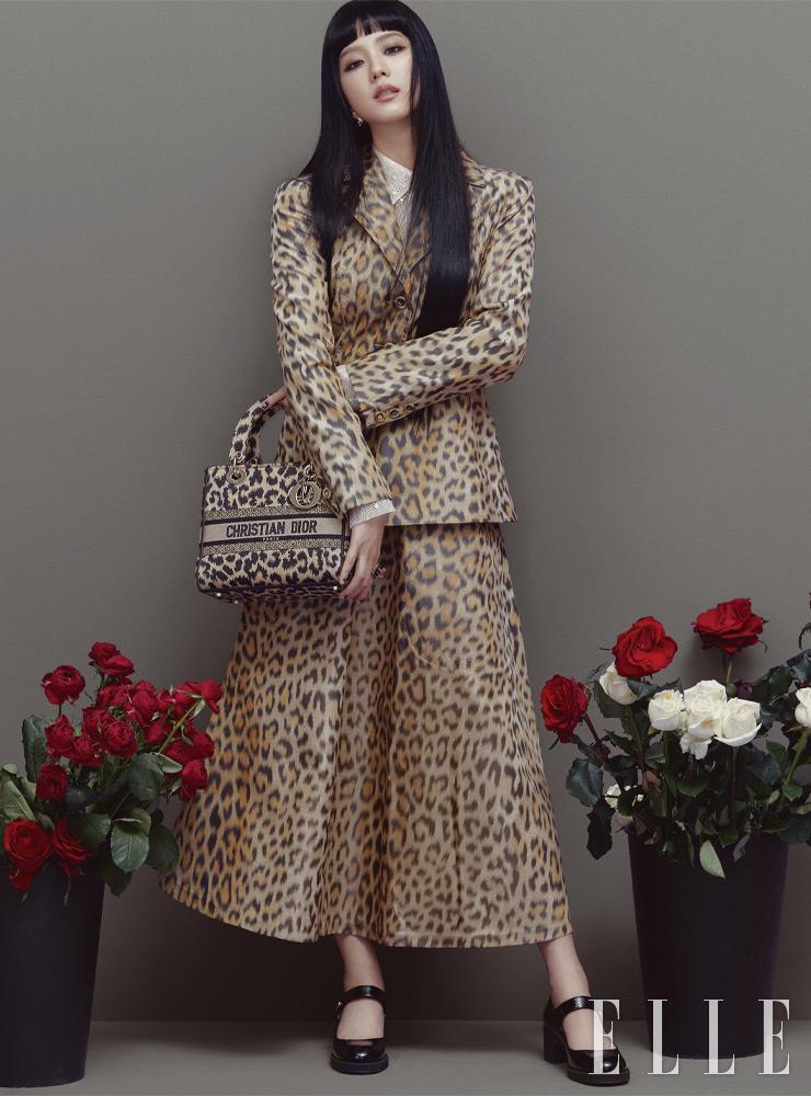 레오퍼드 패턴의 바 재킷, 블라우스, 미디 길이의 스커트, 레이디 디 라이트 백, 이어링과 블랙 메리 제인 슈즈는 모두 Dior.