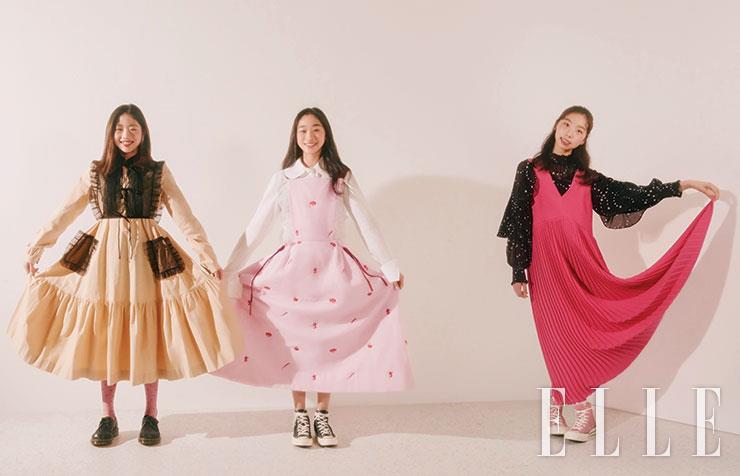 (왼쪽부터) 해인이 입은 블랙 튤 장식의 베이지 원피스는 Minjukim. 글리터 로퍼는 Dr. Martens. 이어링은 Blackmuse. 서영이 입은 화이트 셔츠와 자수 장식의 핑크 원피스는 모두 Minjukim. 블랙 스니커즈는 Converse. 하트 이어링은 Pandora. 연정이 입은 별 프린트의 블랙 프릴 블라우스는 Maje. 플리츠 브이넥 원피스는 Kenzo. 핑크 스니커즈는 Converse. 반지는 모두 Milton Stelle.