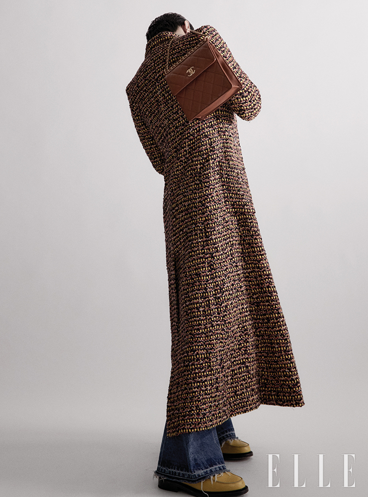 테일러드 롱 코트와 골드 메탈 소재의 시크 체인 백팩은 모두 Chanel.