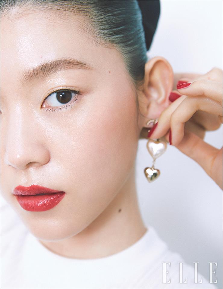 레드 립으로 포인트를 준 모델 청솔의 글로 스킨이 한 폭의 그림처럼 빛난다. 레 베쥬 젤 쿠션으로 피부 톤을 고르게 정돈해 주고, 바움 에쌍씨엘 글로우 스틱, 트렌스페어런트를 광대뼈와 이마, 턱 끝에 발라 윤기를 더한다. 눈꺼풀에도 넓게 발라 글로시함을 더한 뒤 이니미터블 엑스트렘 마스카라, 10 퓨어 블랙을 청키하게 바른다. 광대뼈를 사선으로 감싸듯 레 베쥬 워터-프레시 블러셔, 엥땅스 코랄을 바르고, 차분한 레드 톤의 루쥬 코코 밤, 924 폴 포 미를 입술에 깔끔하게 발라 마무리. 사용 제품은 모두 Chanel. 화이트 톱과 이어링, 진주 체인 벨트는 모두 Chanel. 데님 팬츠는 Arket. 리본 헤어핀은Elizabeth Moment.