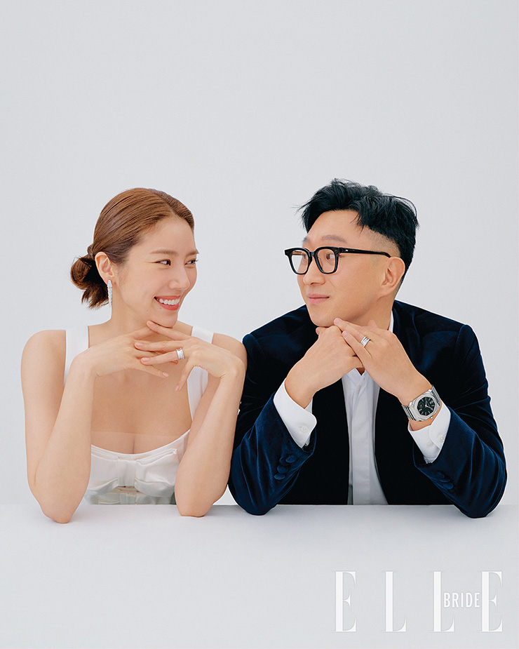 손담비, 이규혁 커플이 함께 착용한 볼드한 디자인에 다이아몬드를 데미 파베 세팅한 비제로원 뉴 클래식 링, 뱀 모양의 드롭형 이어링은 세르펜티 이어링, 스테인리스스틸 소재와 블랙 래커 다이얼의 모던한 옥토 피니씨모 S 워치는 모두 Bvlgari. 사랑스러운 리본 장식 드레스는 Rosario by Kayla Bennet. 네이비 벨벳 재킷과 화이트 셔츠는 모두 Lord and Tailor.