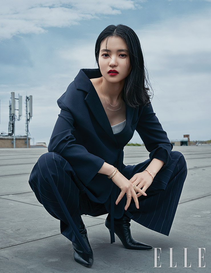 영문 T를 웃는 입 모양으로 형상화한 티파니 T 스마일 펜던트, 왼손에 착용한 티파니 T 와이어 브레이슬렛, 오른손에 레이어드해 착용한 라운드 형태의 티파니 T 투 힌지드 브레이슬렛과 티파니 T 와이어 브레이슬렛, 옐로와 로즈골드 소재의 티파니 T 트루 와이드 링은 모두 Tiffany & Co. 재킷은 Chloé. 팬츠는 Juun. J. 화이트 톱과 슈즈는 모두 스타일리스트 소장품.