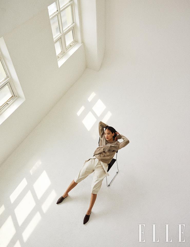  소매를 묶은 듯한 디테일이 돋보이는 니트 톱과 가죽 버뮤다 팬츠는 가격 미정, 모두 Eudon Choi. 브라운 레더 뮬은 가격 미정, EENK.