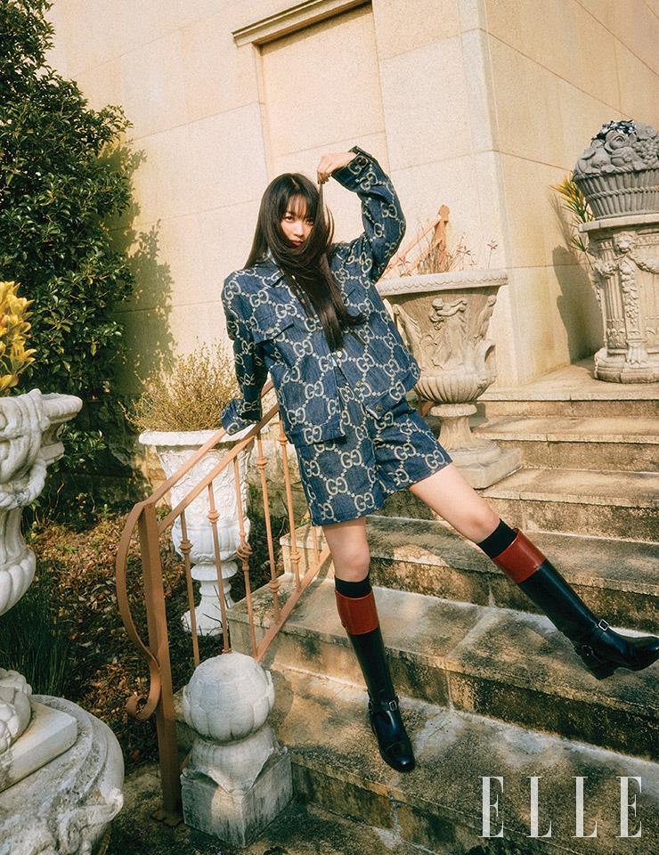 모노그램 패턴의 데님 재킷과 쇼츠, 투 톤 라이딩 부츠, 니 삭스는 모두 Gucci.