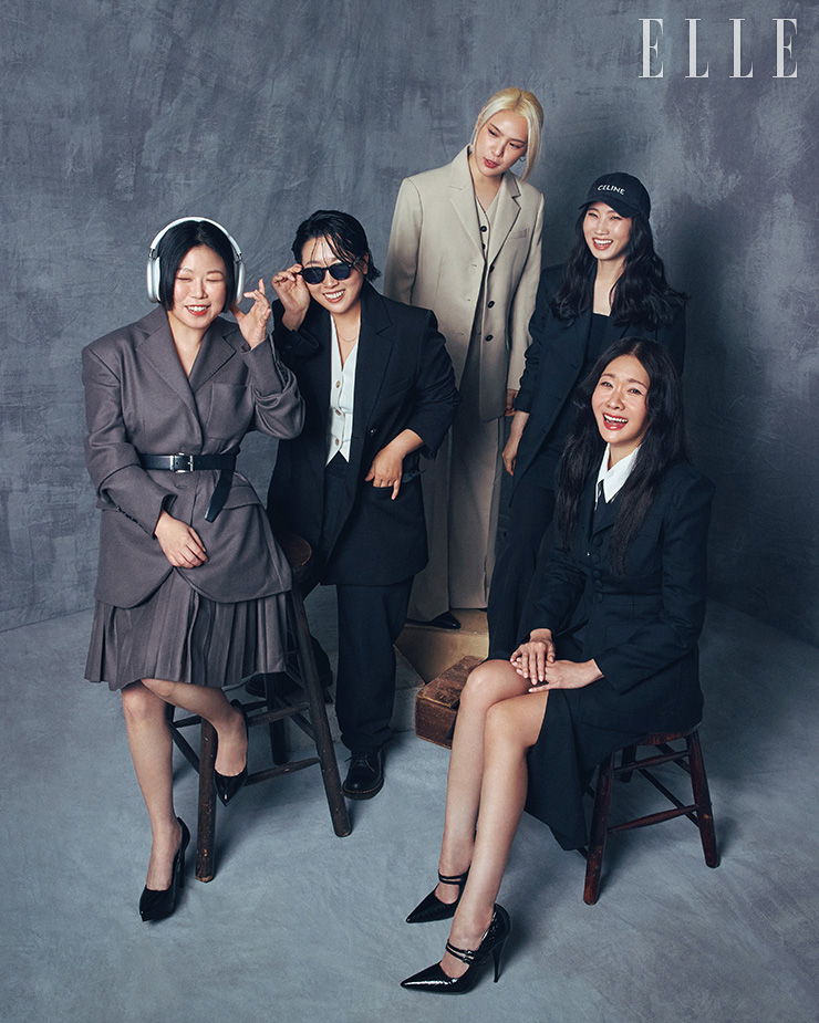 윤신혜가 입은 재킷은 YCH. 벨트는 Prada. 슈즈는 Saint Laurent. 헤드셋은 본인 소장품. 최정남이 입은 수트 세트업은 Foyer. 이너 웨어 베스트는 COS. 선글라스는 Highcollar. 방글이가 입은 재킷과 이너 웨어 베스트, 팬츠는 모두 Clair de Sage. 박희연이 입은 이너 드레스 톱과 팬츠는 모두 Zara. 재킷은 Clair de Sage. 캡은 Celine. 이선영이 입은 재킷과 스커트는 모두 Fayewoo. 슈즈는 Miu Miu. 