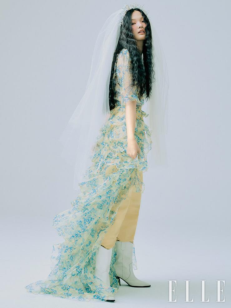 언밸런스 헴라인이 드라마틱한 오간자 드레스는 Dew E Dew E. 옐로 팬츠는 Isabel Marant. 화이트 웨스턴 부츠는 Rachel Cox. 크리스털 장식의 헤어피스는 Sooya. 베일은 My Daughter’s Wedding.