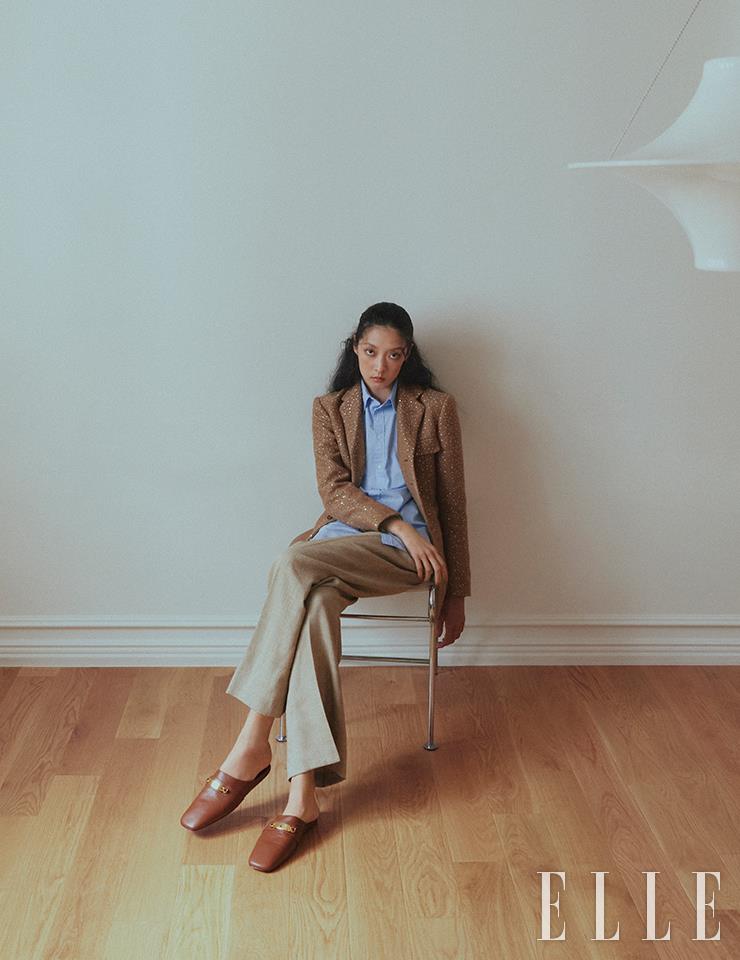 시퀸 장식을 더한 트위드 재킷과 블루 셔츠, 베이지 스트레이트 피트 팬츠, 캐러멜 컬러의 뮬은 모두 Polo Ralph Lauren.