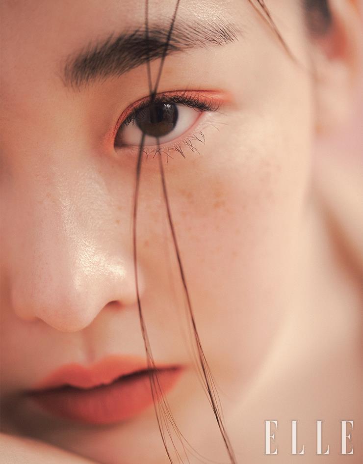 따스한 석양빛으로 물든 김민하의 얼굴. 썸머 언레이티드 블러쉬 브론저 듀오, 오르가즘 엑스/카지노 중 비비드한 코럴 핑크 컬러인 오르가즘 엑스를 아이라인처럼 활용해 쌍꺼풀 라인을 따라 터치했다. 그 다음 딥 브라운 컬러의 카지노로 눈 앞쪽에 가볍게 음영을 준 뒤 클라이맥스 익스트림 마스카라로 위아래 속눈썹에 한 올 한 올 볼륨을 더했다. 더스티 로즈빛의 에어 매트 립 컬러, 돌체 비타를 입술에 부드럽게 스머징하듯 발라 마무리. 사용 제품은 모두 Nars. 브라운 니트 드레스는 Verso.