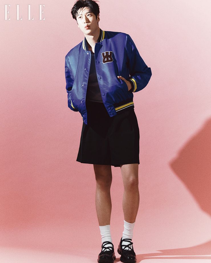 베이스볼  재킷은 Wales Bonner.  쇼츠는 Jil Sander by G. Street 494.  슈즈는 Simone Rocha.  이너  웨어  톱과  삭스는  모두  스타일리스트  소장품 . 