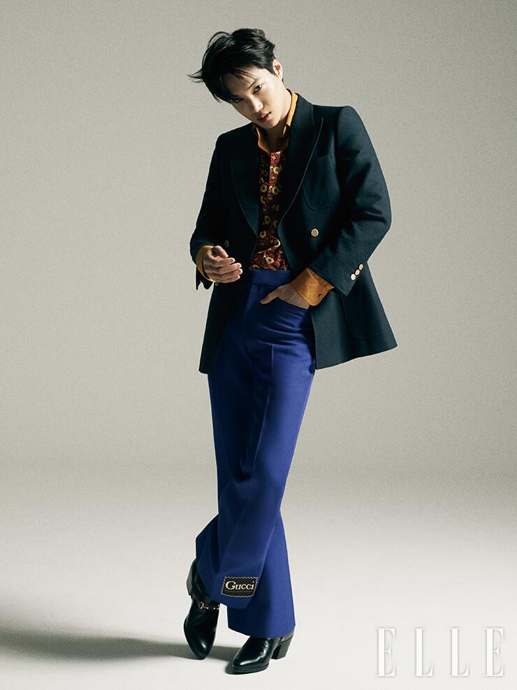 더블 브레스티드 재킷과 플라워 패턴 톱, 안에 레이어드한 셔츠, 로고 장식의 팬츠, 홀스빗 부티 힐은 모두 Gucci.