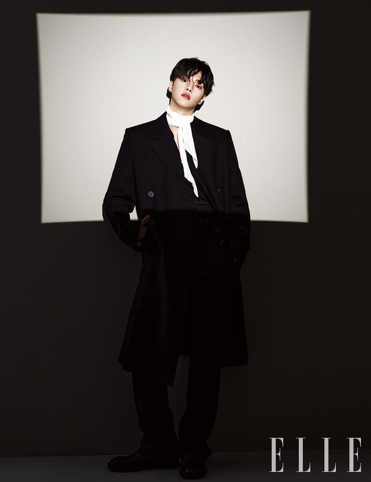 블랙 코트와 팬츠는 Wooyoungmi. 블랙 셔츠와 화이트 실크 스카프는 Kimseoryong. 스퀘어 토 앵클부츠는 Andersson Bell.