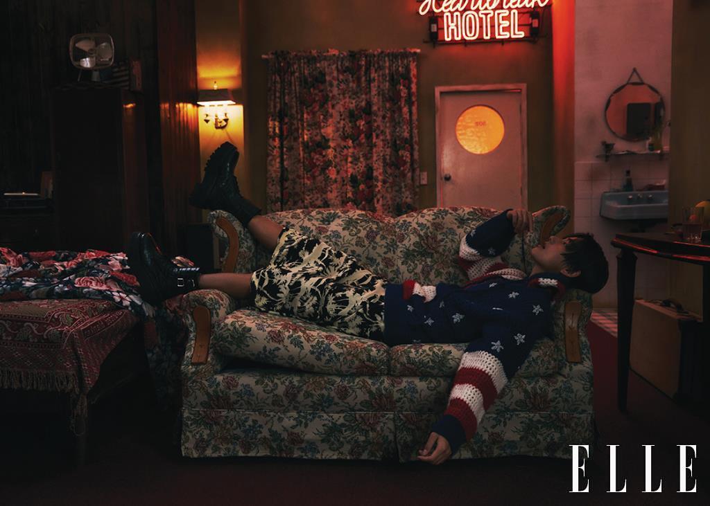 Hooded Knit Top with American Flag Pattern, Maxi Skirt, and Bulky Buckle Boots are all from Celine Homme.