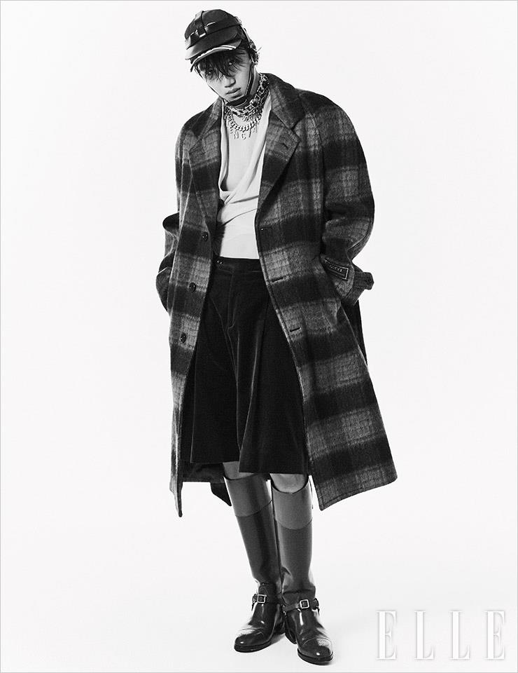 타탄체크 패턴의 롱 코트와 셔츠, 버뮤다 팬츠, 승마 부츠, 볼 캡과 가죽 헤드기어, 레이어드한 네크리스는 모두 Gucci.