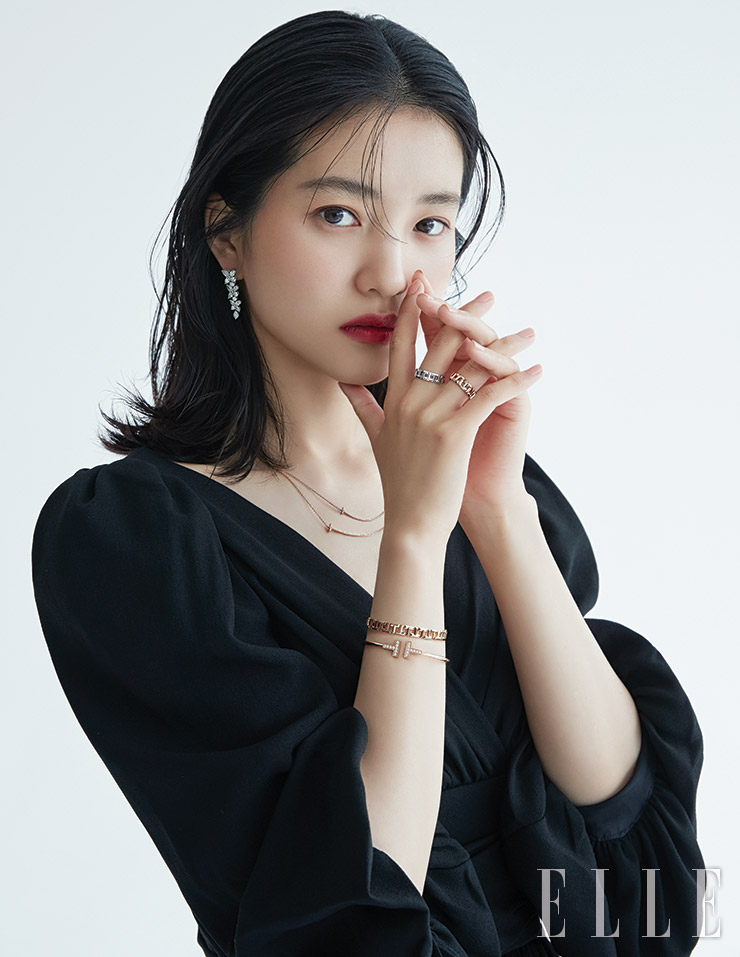 별에서 모티프를 얻은 다이아몬드 세팅의 티파니 빅토리아 믹스드 클러스터 드롭 이어링, 영문 T를 그래픽적으로 표현한 티파니 T 스마일 펜던트, 레이어드한 화이트골드와 로즈골드 소재의 티파니 T 트루 와이드 링, 티파니 T 와이어 브레이슬렛과 티파니 T 트루 내로 브레이슬렛은 모두 Tiffany & Co. 블랙 미니드레스는 Celine by Hedi Slimane.