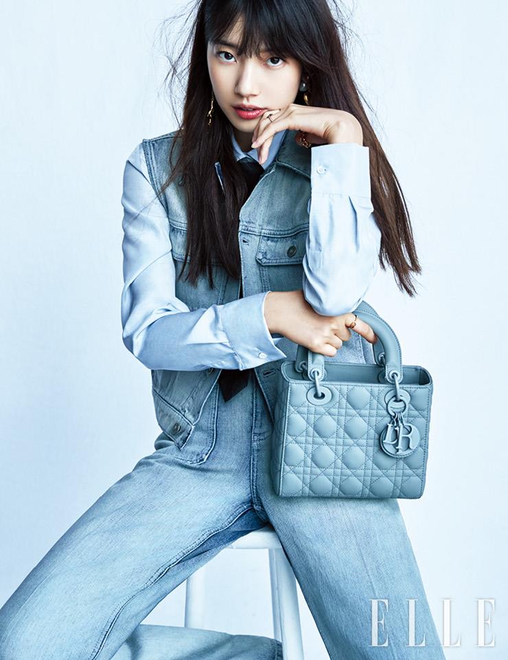 데님 베스트와 팬츠, 블루 셔츠, 타이, 드롭 이어링, 양손에 착용한 골드 링, 송아지가죽으로 만든 레이디 디올 백은 모두 Dior.